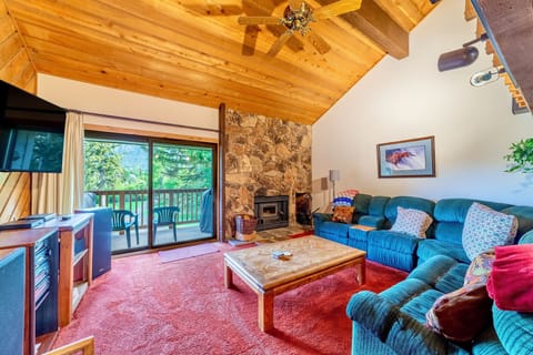Open living room with vaulted ceilings, wood burning fireplace, and plenty of natural light.