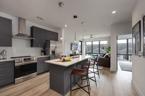 Unit 1: Fully equipped kitchen stocked with your basic cooking essentials. Includes stainless steel appliances, small kitchen island, coffee machine, and toaster.