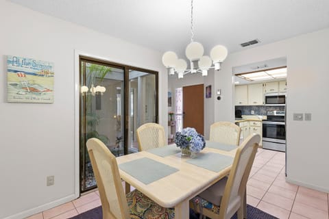 This bright dining space flows seamlessly into the fully equipped kitchen and features coastal décor and patio views. The perfect place to gather for meals and plan your next adventure during a relaxing beach stay getaway.