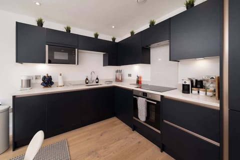 Cook in style in the deep blue open-plan kitchen, where modern design meets functionality for a sleek and inviting space.