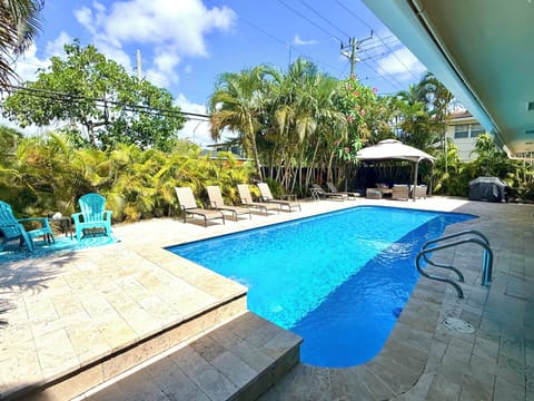 Pool area with loungers, canopy and BBQ