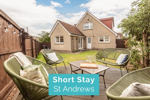 Private garden with modern patio furniture and a wooden deck, perfect for relaxing outdoors.