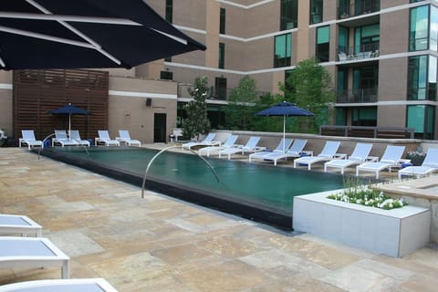 Unwind poolside on sleek loungers in a serene courtyard.