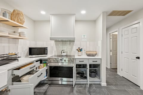 Cook like a pro with this high-end oven and gas range, tucked beneath a custom range hood and tile backsplash.