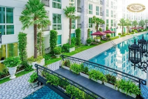 Piscine bordée de palmiers, passerelles élégantes et transats avec parasols pour une détente absolue. Profitez d'un cadre verdoyant et raffiné dans un environnement luxueux et apaisant.