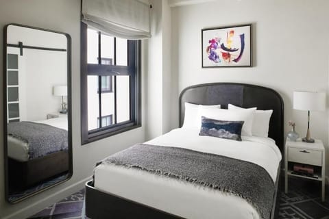 Recharge in a calm, minimalist room with plush bedding.