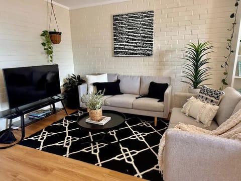 Kick back and relax! This comfortable living area offers plush seating, a TV for movie nights, and books for quiet moments. It’s the ideal spot to unwind and make yourself at home!
