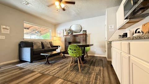 A wide window lets in natural light across the living and kitchen areas, perfect for working, lounging, or dining.