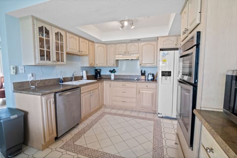 Cook up your favorite meals in this spacious kitchen featuring modern appliances, ample counter space, and coastal charm—perfect for enjoying delicious dishes during your beach getaway.