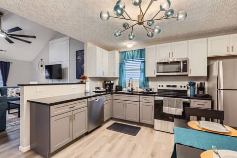 A fully equipped kitchen with modern appliances, quality utensils, spacious countertops, and a coffee setup for your convenience.