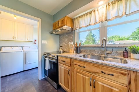 Fully stocked kitchen with electric stove overlooking the fenced in back yard.