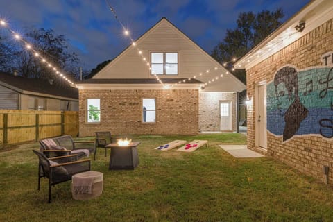 Step into your very own backyard paradise, complete with a cozy fire pit, fun cornhole, and a sizzling BBQ grill—all beautifully lit with charming string lights for that perfect evening glow.

