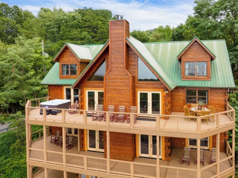Spacious exterior with several furnished decks and a hot tub for ultimate comfort.