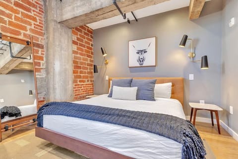 Sink into the plush bed framed by brick-and-concrete character.