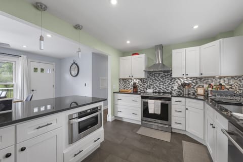 Modern kitchen with sleek countertops, built-in microwave, and pendant lighting.
