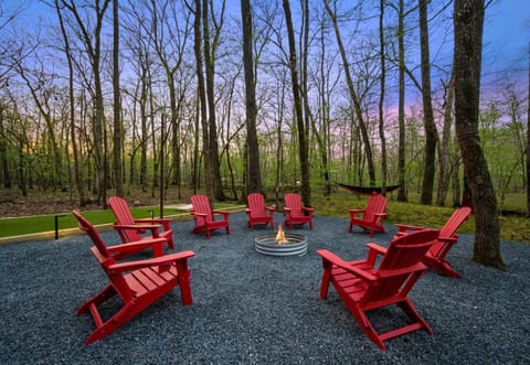 The fire pit area, complete with Adirondack chairs, creates a welcoming space to gather, share stories, and enjoy the evening air.