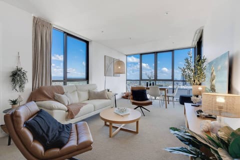 Unwind in the stylish living area with plush seating, curated decor, and panoramic views stretching across the coast and city.