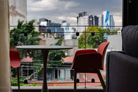 Outdoor cafe setting with a table, chairs, and a view of the city skyline.
