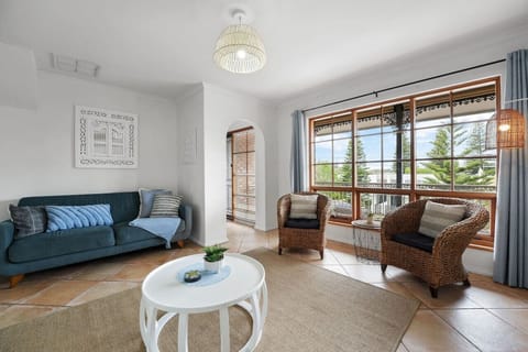 Settle into the light-filled living area, where a comfortable sofa and armchairs create an inviting place to unwind after a day at Grange Beach.
