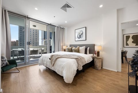 Wake up to skyline views from the king bed in the primary suite, complete with mirrored wardrobes, an accent chair and direct balcony access for peaceful mornings.