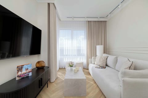 Living room with a large, comfortable sofa, an elegant coffee table, and a wall-mounted TV offers the perfect place to relax.