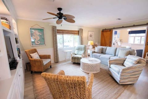 Spacious, sunlit living room with cozy seating and Smart TV—perfect for movie nights, family hangouts, or relaxing after a day at the beach.