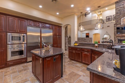State of the art, completely stocked kitchen features 2 refrigerators and an island with a mini wine fridge.