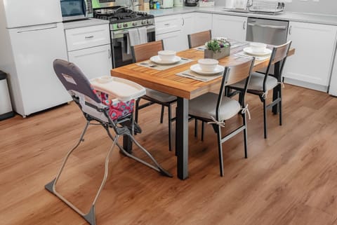 Dining area featuring a highchair next to the wooden table, family-friendly space.