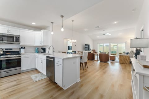 Kitchen (w/ separate breakfast table) leads to the dining area and shared living room, overlooking the lanai