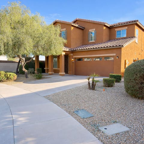 Spacious two-story home with driveway parking and desert landscaping.