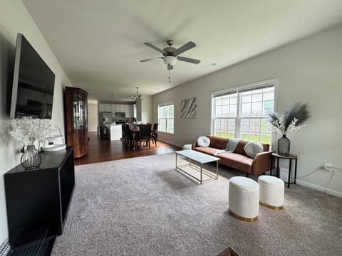 Bright, open living room connecting into dining and kitchen