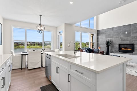 Spacious kitchen island with sink, dishwasher, and beautiful lake views for the whole family