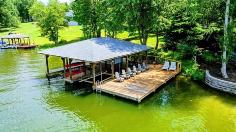 Dock - Aerial view of the covered dock with Adirondack chairs, boat slips, and kayak storage on the water.