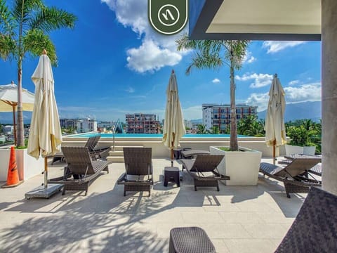 Stunning rooftop oasis with infinity pool, sun loungers, and sweeping mountain + city views—perfect for sunset dips and relaxing under blue skies.