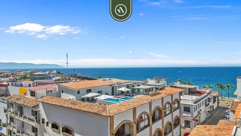 An elevated perspective of the rooftop overlooking the cityscape and the deep blue ocean.