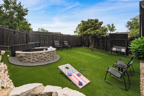 Shared backyard with cornhole, outdoor dining table, ample seating, and pool.