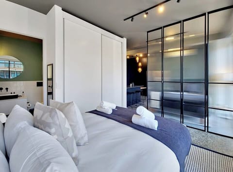 View of the bedroom looking to the en-suite bathroom and into living room