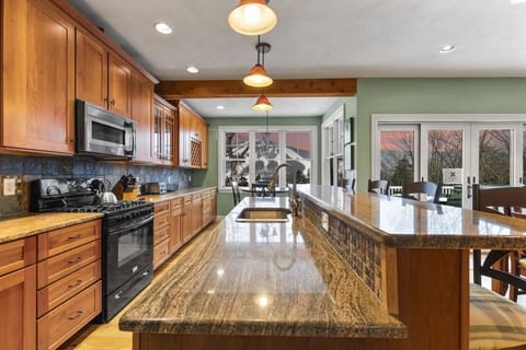 Open-concept kitchen with breakfast bar and seating for 4. Also has the breakfast nook in the back, and the 10-person dining table is just behind the breakfast bar.