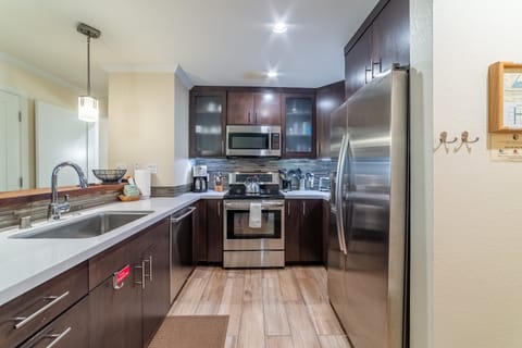 Updated kitchen with stainless steel appliances and solid stone countertops.