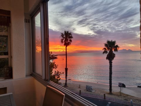Enjoy a beautiful sunset view of the beach from an enclosed balcony. 
