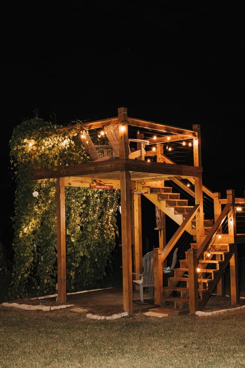 The Garden Tower on a summer night. String lights and blooming moonflowers.