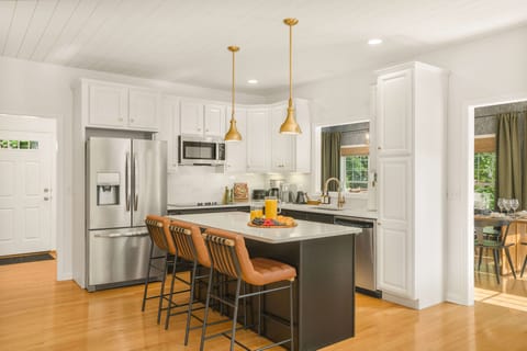 Bright, open-concept kitchen featuring crisp white finishes and abundant natural light—perfectly designed for gathering, cooking, and connecting, with effortless access to both the front and rear decks and the fresh mountain air just steps away.