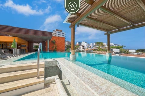 Step easily into the sparkling rooftop pool. Enjoy the shade from the elegant wooden pergola while taking in the stunning panoramic views of the city and ocean beyond.