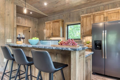 Modern kitchen with island seating and stainless steel appliances.