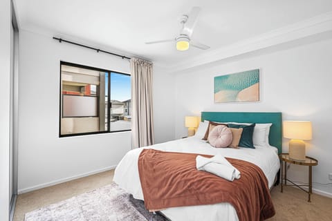 Luxurious master suite featuring a full-height window, designer bedding, and a serene, spacious atmosphere.