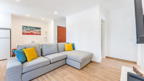 Spacious and bright living area with a comfortable sofa and modern décor. Perfect for relaxation or socializing. Enjoy the air conditioning and a flat-screen TV for entertainment. #LivingRoom #BrightSpace #Relaxation #ArmaçãoDePêra #CozyBalcony