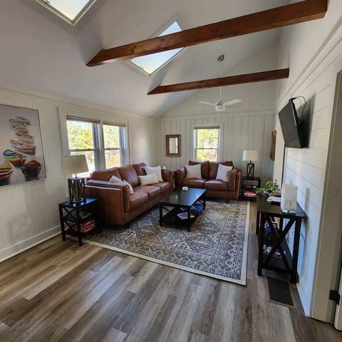 Gather and unwind. Our inviting living room features plush couch and loveseat, comfortable pillows, high ceilings, and abundance of natural light through skylights and windows.