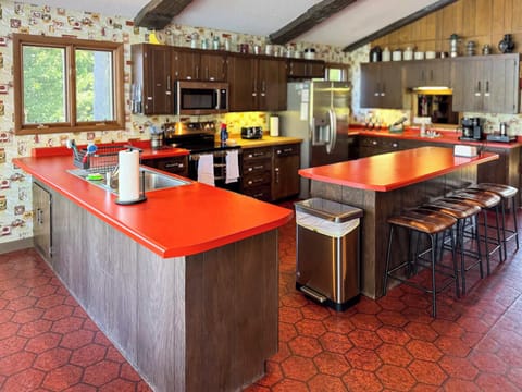 View of the full kitchen and the center island eat-in seating for four and with visibility across the entire great room, dining, living room, entertainment space