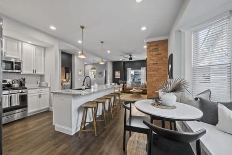 Modern kitchen with stainless steel appliances and granite countertops - Spacious island seating ideal for meals or conversation - Open layout connects kitchen to living and dining areas