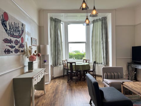 Open-plan living room w high ceiling and big bay window